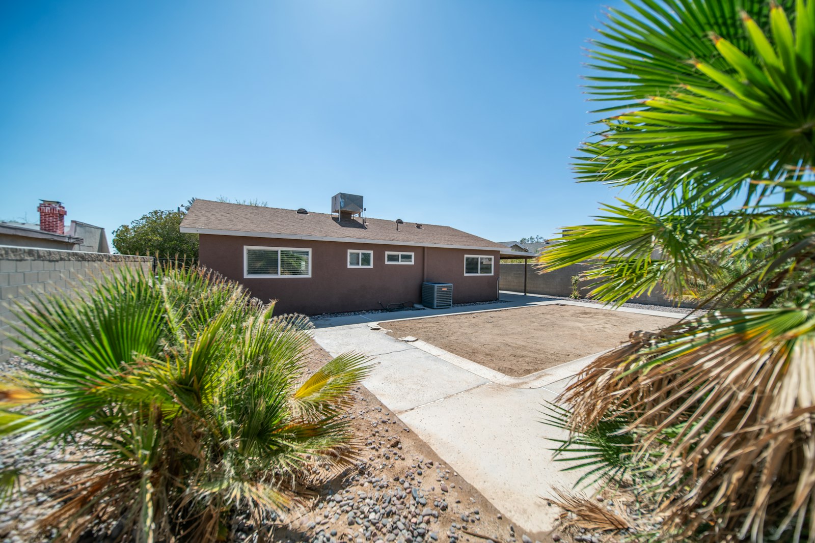 Phoenix home with a single tall palm and a clean rock front yard.